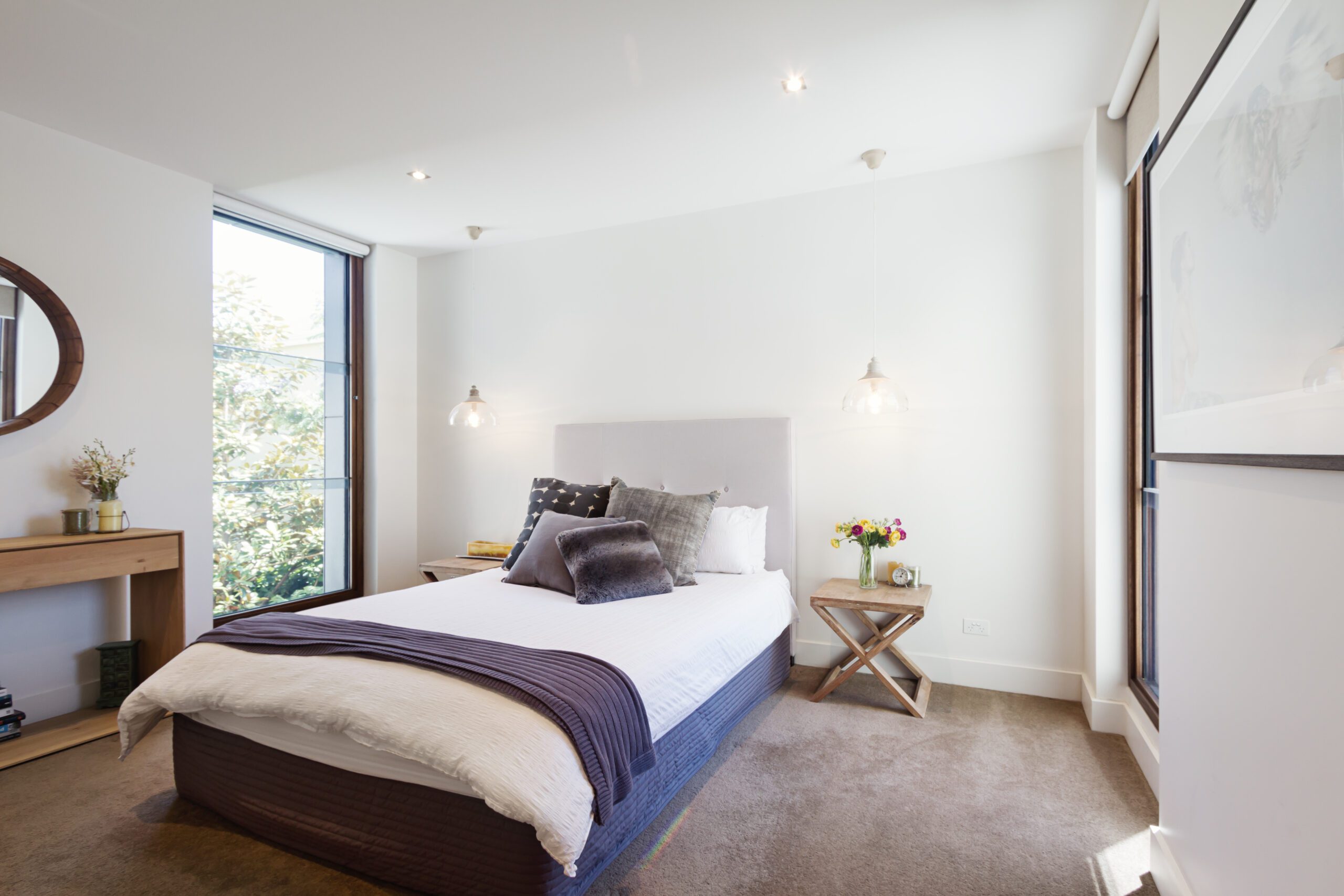 Luxury interior designed bedroom with comfy pillows and throw rug and pendant lights